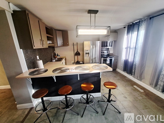 A white fridge and a black stove top oven in a kitchen.