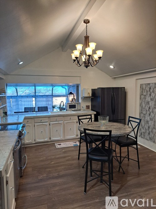 A kitchen with a table and chairs in the middle of the room.