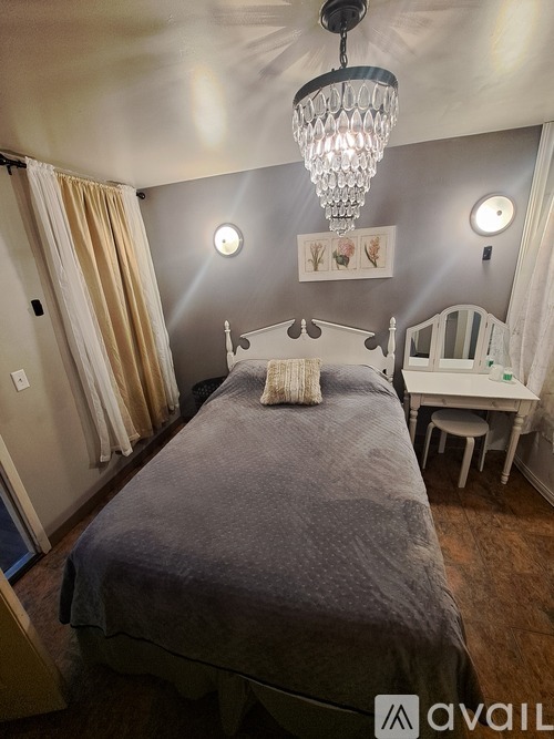 A bedroom with a bed, nightstand, and chair.