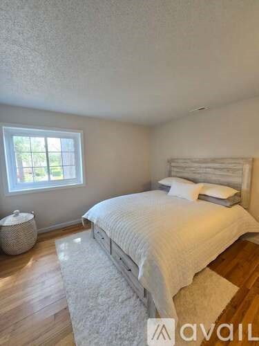A bedroom with a large bed and a window.
