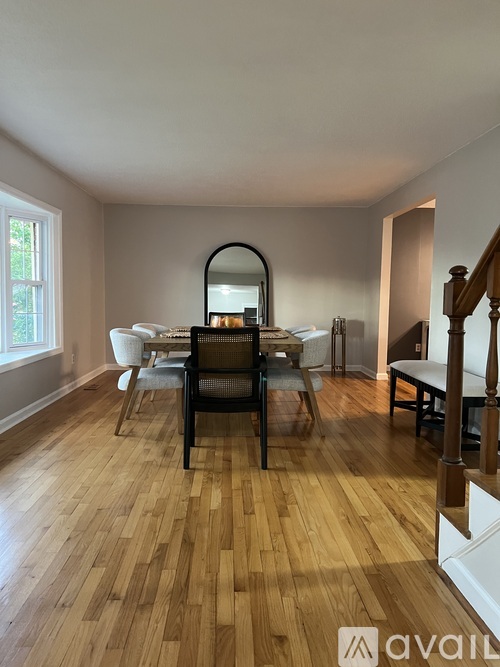 A dining room with a wooden floor and a white table.