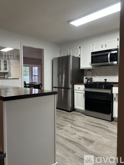 A kitchen with a black countertop and stainless steel appliances.