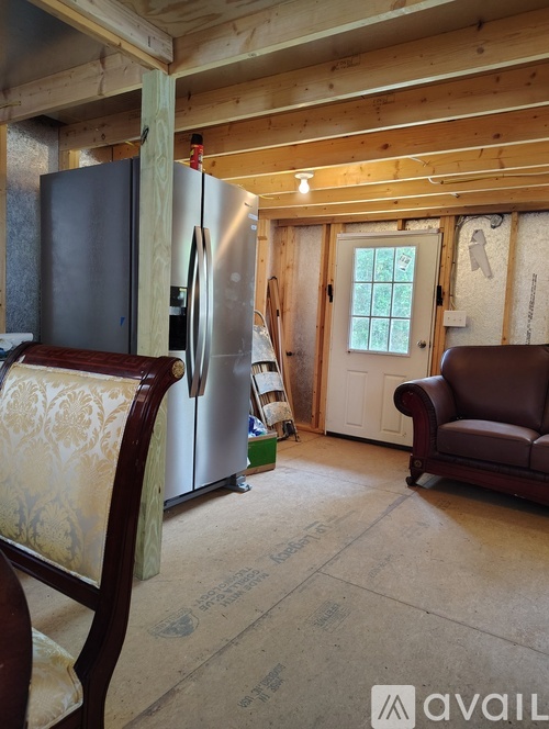 A kitchen with a refrigerator and a couch.