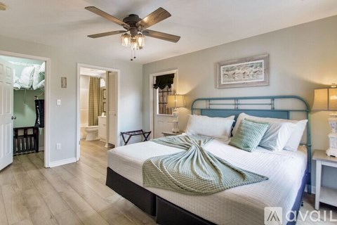 A bedroom with a large bed and a ceiling fan.