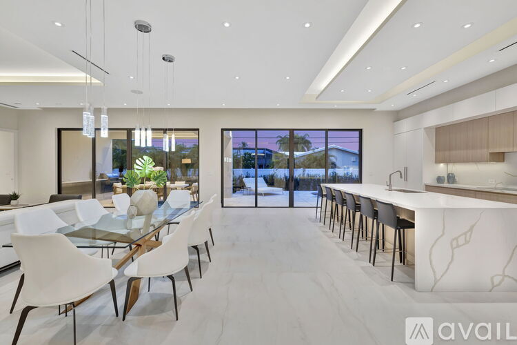 A modern dining room with a glass table and chairs.