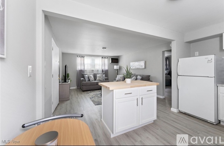A modern kitchen with white cabinets and a wooden island.
