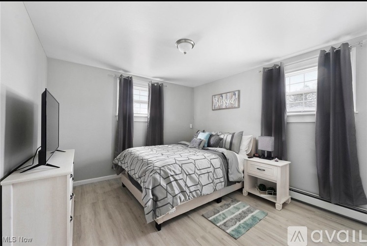 A bedroom with a bed, nightstand, and television.
