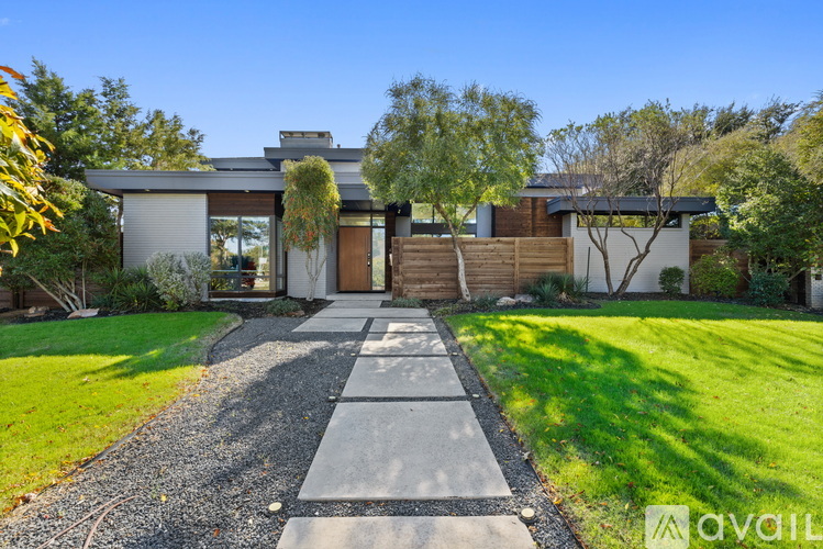 A modern house with a gravel pathway leading to the entrance.