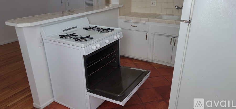 A white stove with an open oven in a kitchen.