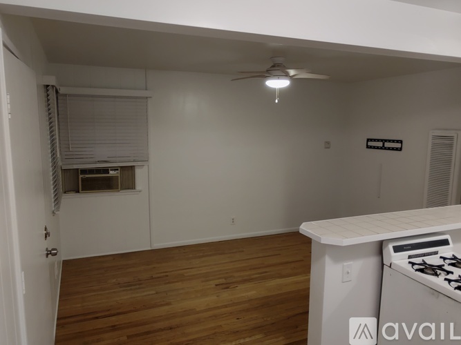 A room with a wooden floor and a white ceiling fan.