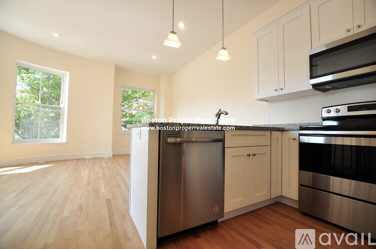 A kitchen with wooden floors and stainless steel appliances.