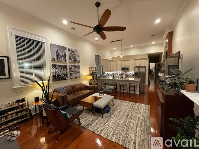 A living room with a ceiling fan and a dining area in the background.