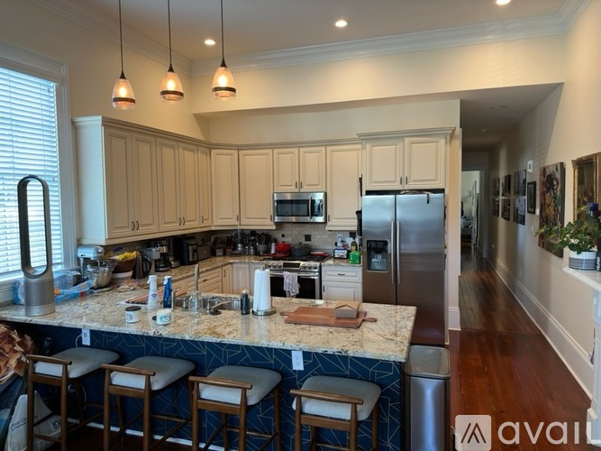 A kitchen with a granite countertop and stainless steel appliances.