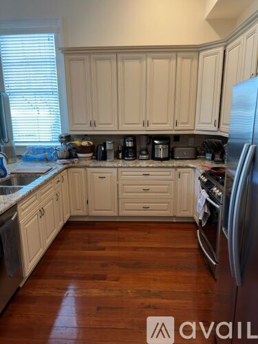 A kitchen with wooden cabinets and a stainless steel refrigerator.