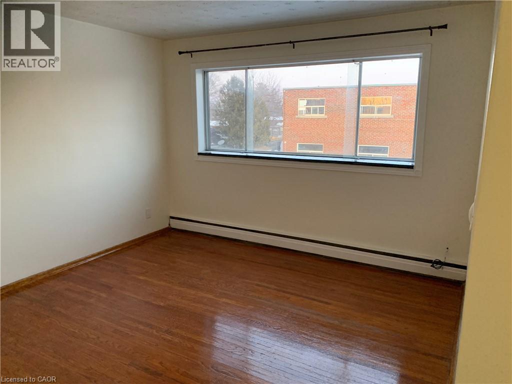 Empty room with a window and wooden flooring.