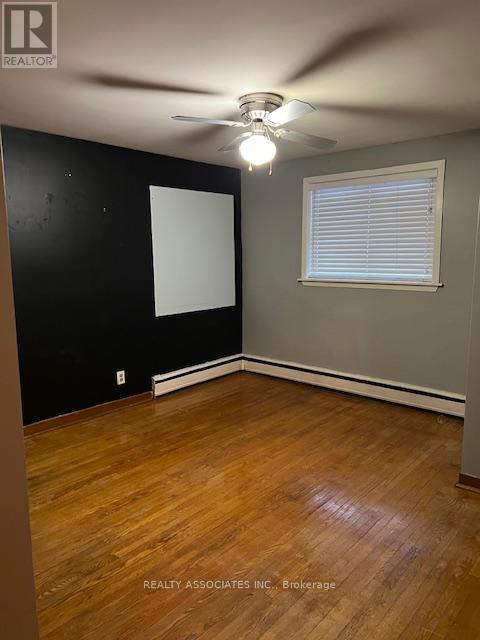 A room with a ceiling fan and a window with blinds.