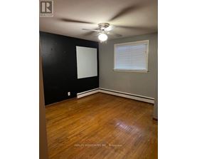 A room with a ceiling fan and a window with blinds.