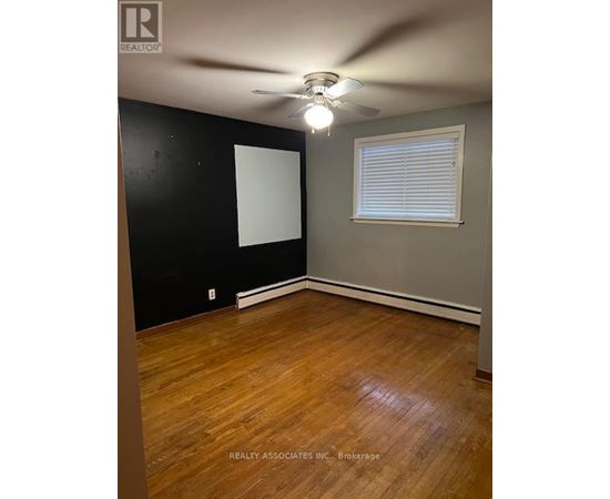 A room with a ceiling fan and a window with blinds.