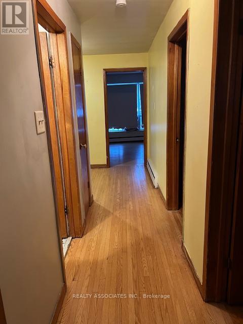 A hallway with wooden floors and doors on both sides.