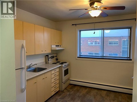 A kitchen with a refrigerator, sink, stove, and oven.