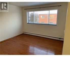 Empty room with a window and wooden flooring.