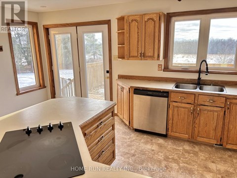 A kitchen with wooden cabinets and a black stove top.