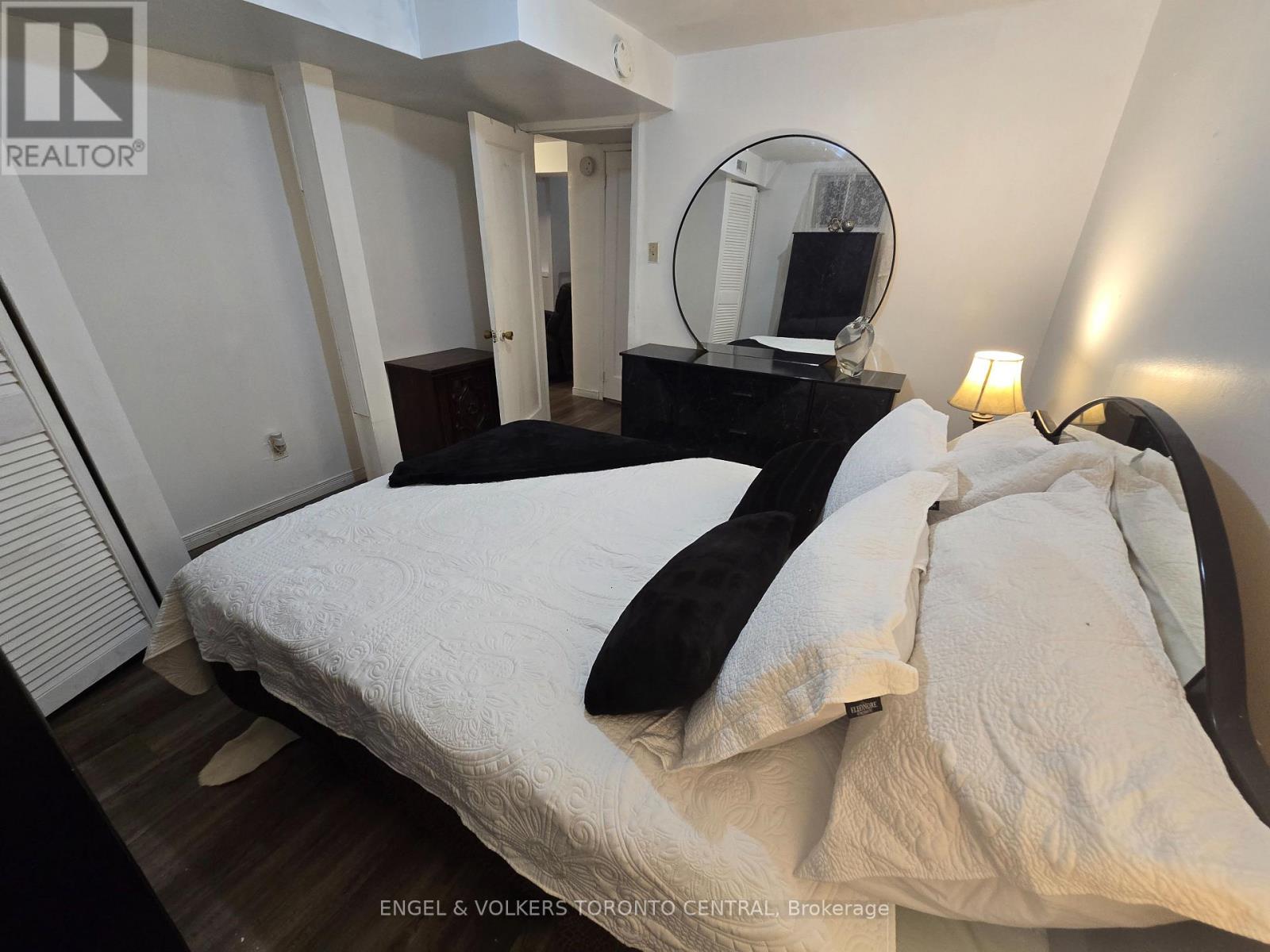 A bedroom with a bed, a dresser, and a mirror.