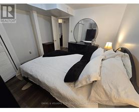 A bedroom with a bed, a dresser, and a mirror.