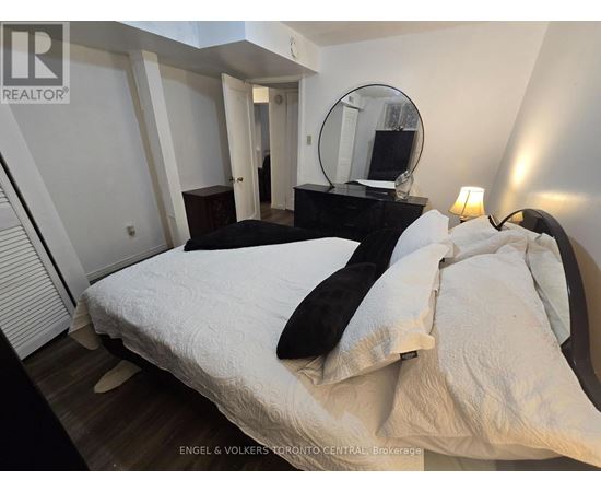 A bedroom with a bed, a dresser, and a mirror.