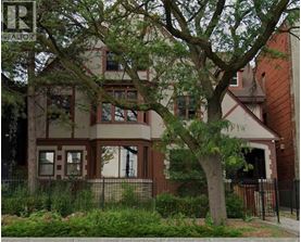 A brown house with a tree in front of it.