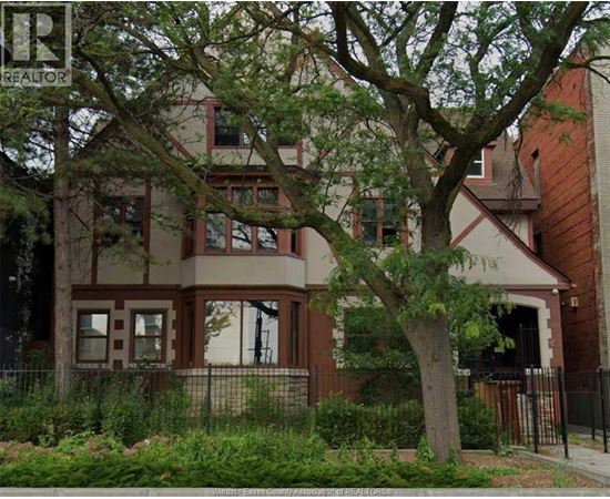 A brown house with a tree in front of it.
