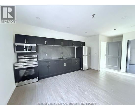 A kitchen with black cabinets and stainless steel appliances.
