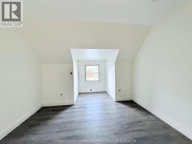 A spacious room with a window and a skylight.
