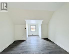 A spacious room with a window and a skylight.