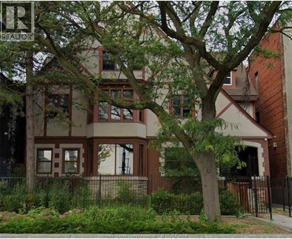A brown house with a tree in front of it.
