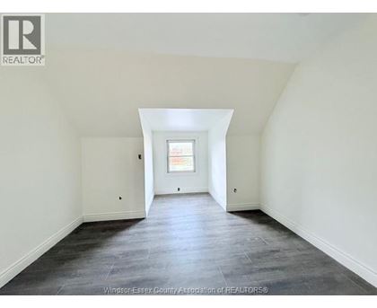 A spacious room with a window and a skylight.