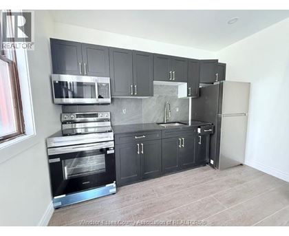 A kitchen with black cabinets and stainless steel appliances.
