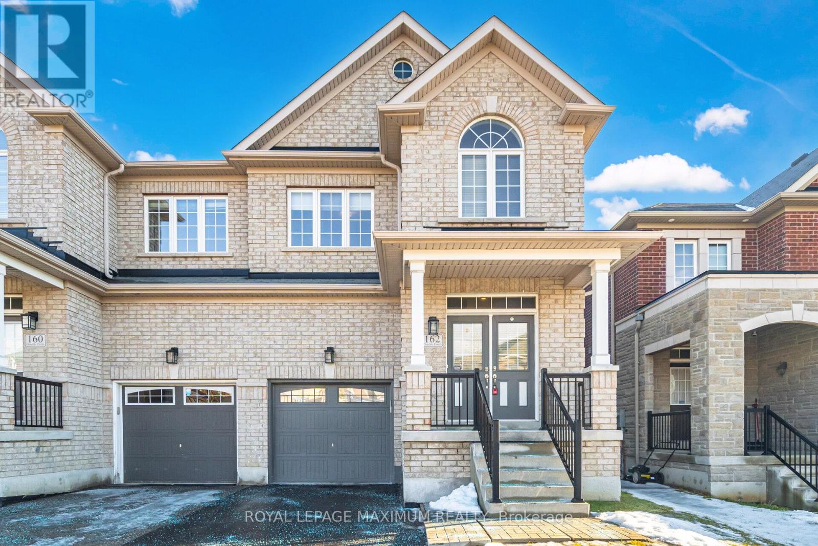 A large, two-story house with a garage and a driveway.