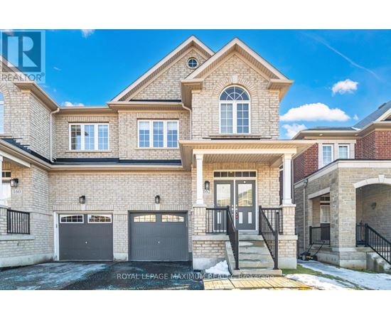 A large, two-story house with a garage and a driveway.