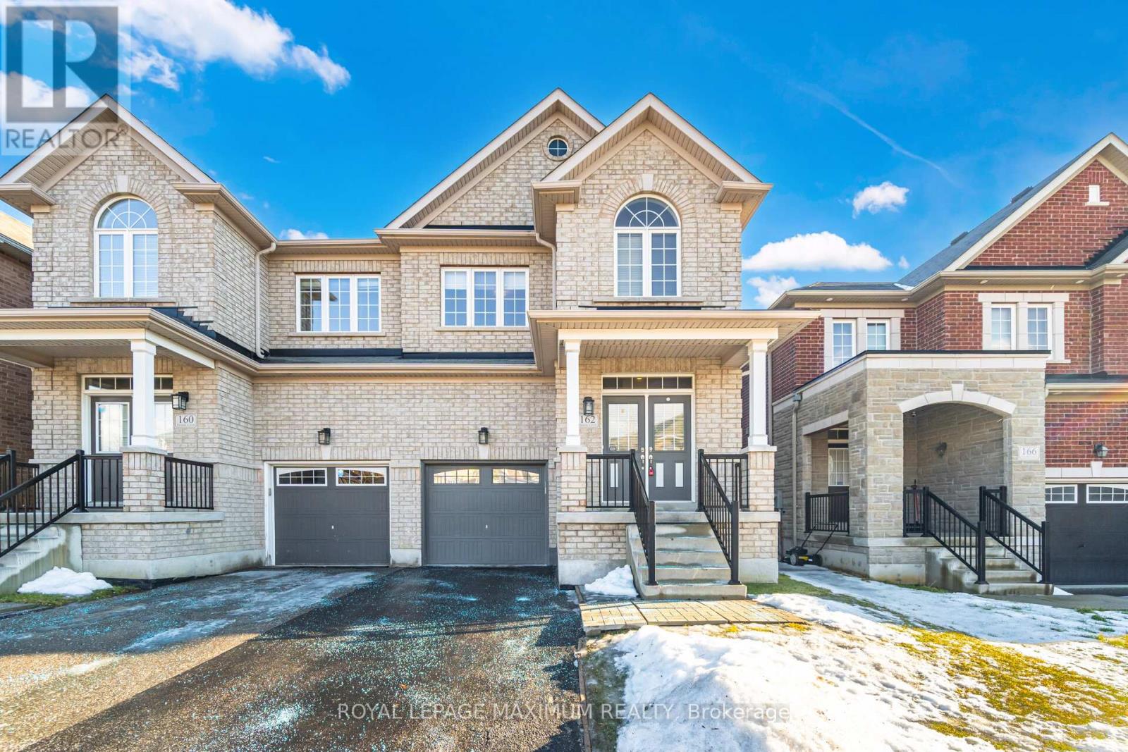A large, two-story house with a garage is situated in a residential area.