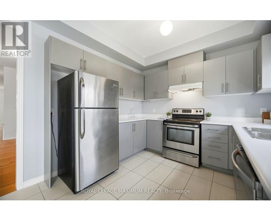 A modern kitchen with a stainless steel refrigerator and oven.