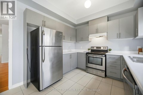 A modern kitchen with a stainless steel refrigerator and oven.