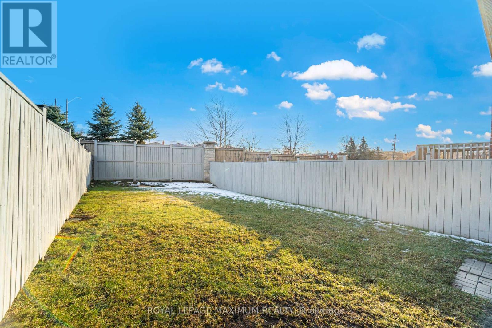A backyard with a fence and grass.