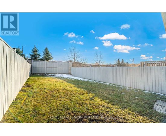 A backyard with a fence and grass.