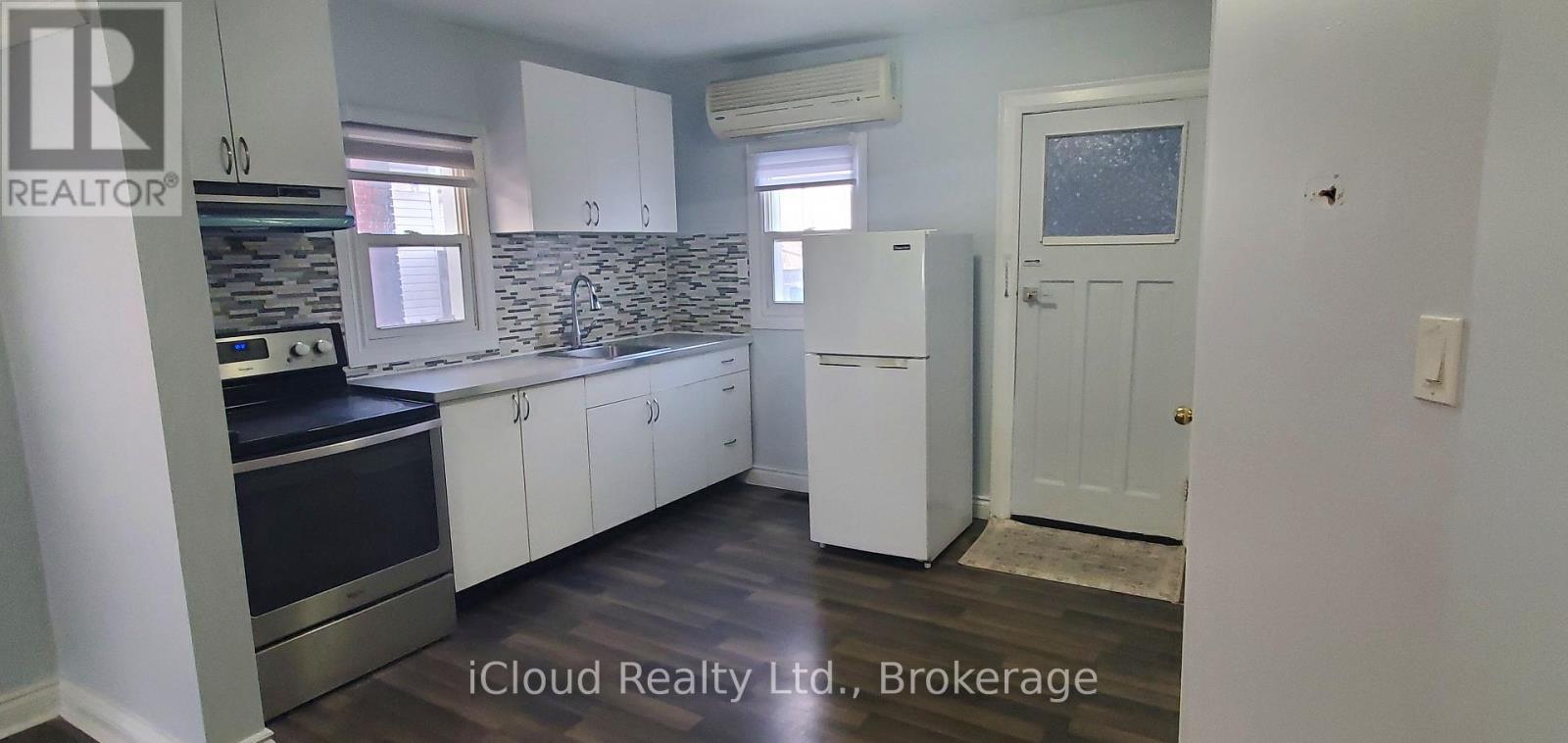A kitchen with white cabinets and a black countertop.