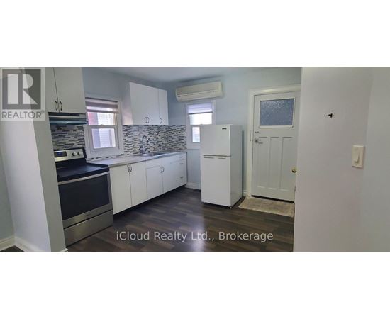A kitchen with white cabinets and a black countertop.