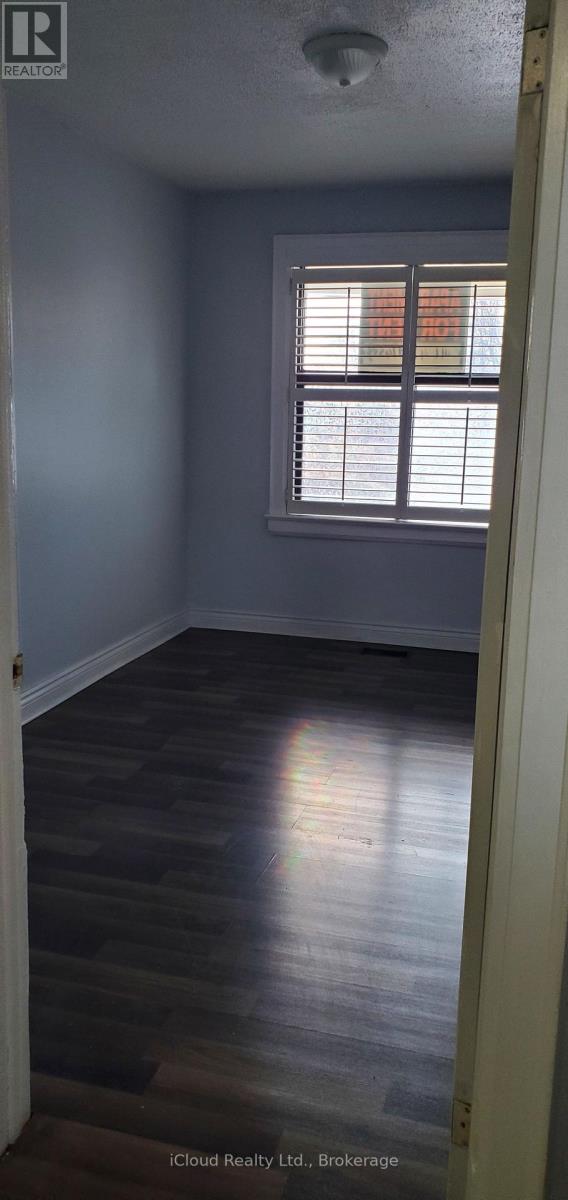 A room with a window and wooden flooring.