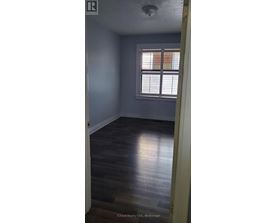 A room with a window and wooden flooring.