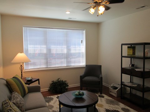 a living room with a couch and a chair and a window