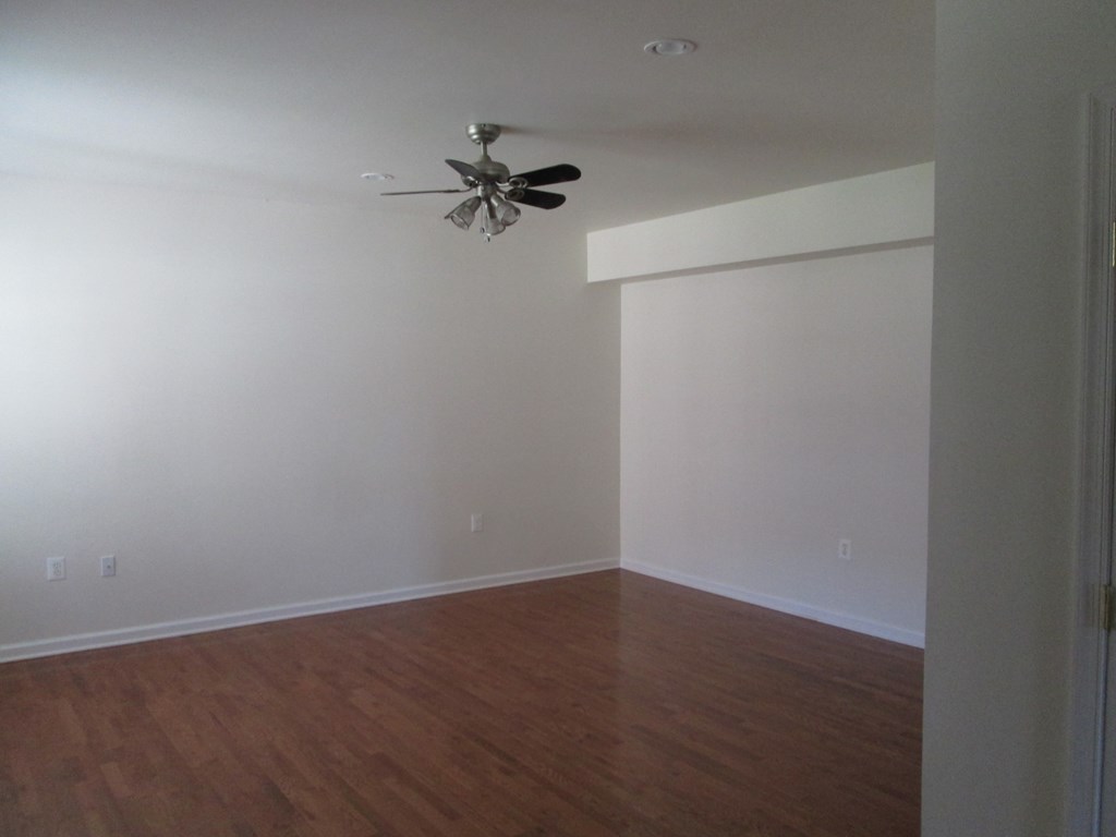an empty room with white walls and a ceiling fan